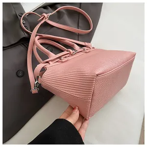 Dettaglio della borsa rosa con doppia texture, hardware argento e tracolla regolabile