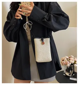 Detailed texture of woven straw mini crossbody bag with drawstring and wood button
