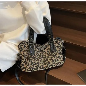 Detail of leopard print handbag with black leather trim and gold rivet studs on steps
