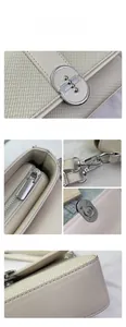 Detailed macro view of beige faux leather stitching and silver metal buckle on the bag