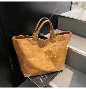Detail of waterproof brown paper tote bag with transparent PVC layer and TOTE BAG text