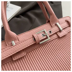 Dettaglio in pelle martellata rosa e trama a pieghe con fibbia argento sulla borsa