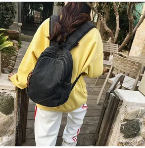 Outdoor view of a large capacity washed denim backpack with adjustable shoulder straps
