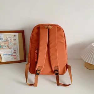 Minimalist orange school backpack for students with padded shoulder straps and side zipper