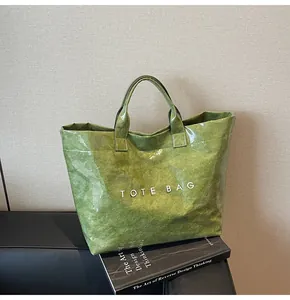 Detailed macro view of green waterproof DuPont paper tote bag with wrinkled glossy texture