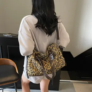 Stylish large leopard print tote bag with brown leather handles for women on a model