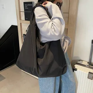 Large black nylon tote bag with drawstring detail, lightweight commuter shoulder bag for women