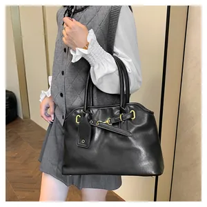 Détail du grand cabas en cuir noir mat avec boucles dorées et lanières décoratives
