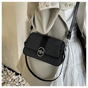 Detail of black tweed and leather crossbody bag featuring a silver oval metal lock