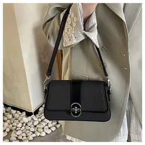 Close-up of black woven texture crossbody bag with silver oval buckle and leather strap