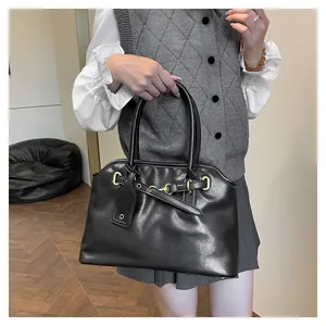 Détail d'un sac cabas en cuir noir élégant avec double poignées et boucles dorées
