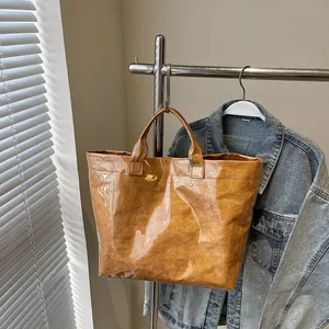 Detail of waterproof PVC layered Tyvek tote bag with reinforced handles and paper texture