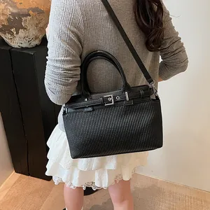 Elegante borsa a mano nera con trama plissettata vista dalla prospettiva di una modella