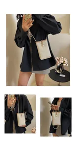 Detail of straw woven mini crossbody bag with elegant pearl drawstring closure and strap