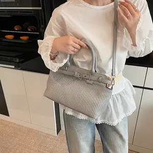 Borsa a mano grigia retrò in pelle a grana con dettagli pieghettati sulla modella