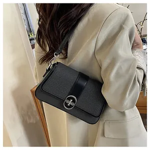 Detail of woven texture and silver metal buckle on a black crossbody bag for women