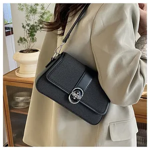Detail of black crossbody bag with woven texture flap and silver rhinestone buckle