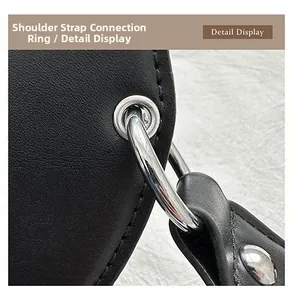 Detail view of the silver metal ring connector and stitching on guitar-shaped bag strap
