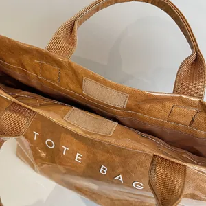 Detail of brown paper tote bag with PVC layer showing Velcro closure and fine stitching