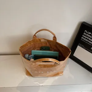 Interior view of brown paper tote bag showing laptop and bottle storage capacity