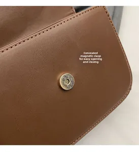 Detail of hidden magnetic buckle on brown leather bag with geometric textured hardware