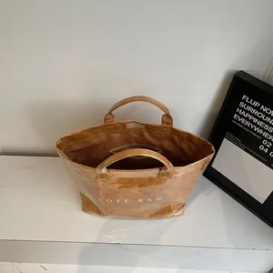 Detail view of large brown tote bag interior with zipper pocket and crinkle texture