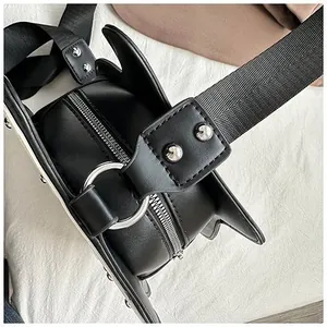 Detail of guitar shaped bag showing black PU leather, silver studs and metal ring puller
