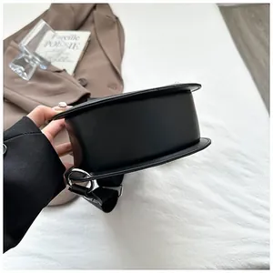 Side view of black guitar-shaped bag showing matte synthetic leather and wide strap