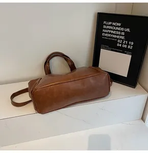 Brown vintage faux leather tote bag with round handles on marble steps detail view