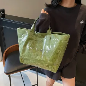 Green Tyvek tote bag with transparent waterproof cover and white text logo for daily commute