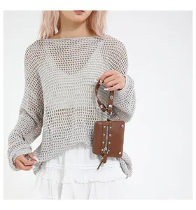 Detail of a brown leather mini bag with vertical zipper and silver studs on white backdrop