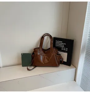 Detailed view of brown tote bag with large front pockets on marble surface