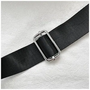 Detail of black nylon guitar bag strap with adjustable silver metal buckle