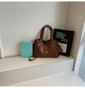 Detail view of large brown vintage tote bag with functional pockets and tablet storage