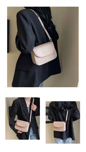 Detail of beige square shoulder bag with gold hardware and smooth leather texture