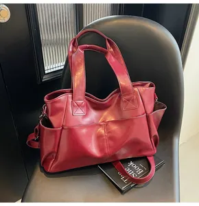 Macro shot of dark burgundy tote bag featuring side pockets and fine leather texture