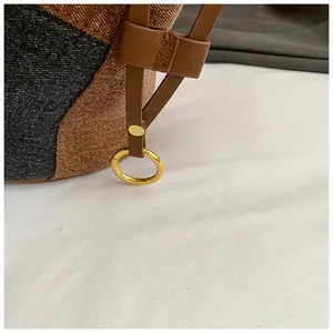 Gros plan du sac cabas en denim vintage avec lanière en cuir et anneau en métal doré