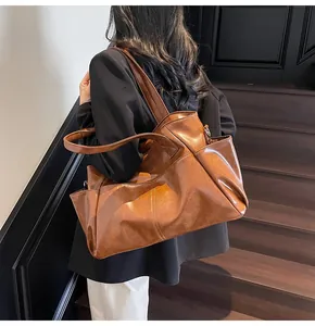 Detailed side view of a brown leather tote bag with large capacity and side pockets