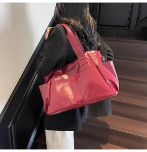 Deep burgundy leather tote bag with functional pockets and reinforced stitching on model
