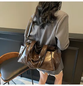Dark brown leather tote bag with side pockets shown in a professional lifestyle setting