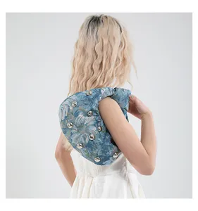 Detailed view of blue floral jacquard crescent bag with silver metallic stud accents