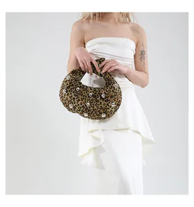 Detail of leopard print tote bag with silver studs and unique knotted handle design
