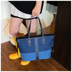 Détail du grand sac cabas en denim bicolore avec poignées en cuir en situation réelle