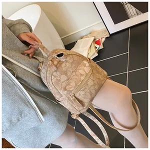 Detail of light brown jacquard mini backpack with floral patterns and golden zippers