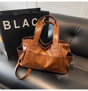 Detailed view of brown tote bag featuring fine stitching and practical front pocket