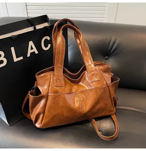 Detailed top view of large brown vintage leather tote bag with handles and shoulder strap