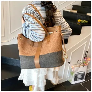 Détail des coutures contrastées du sac fourre-tout en denim avec lanières en cuir