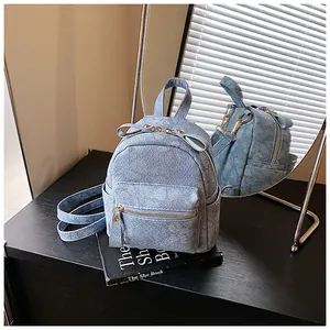 Chic blue denim mini backpack with butterfly knot and floral patterns on black book stand