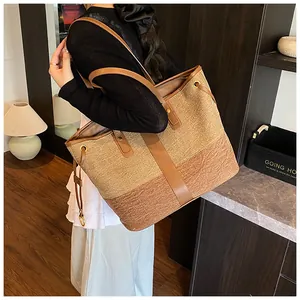 Détail du grand sac cabas bicolore en tissu avec anses en cuir marron et cordons de serrage