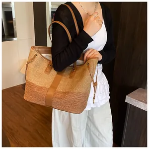 Détail du sac cabas bicolore en toile texturée avec bandoulière en cuir marron élégante
